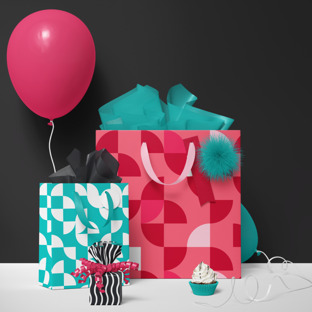 Bold retro geometric gift bags in teal, pink, and black styled with party balloons and a cupcake.