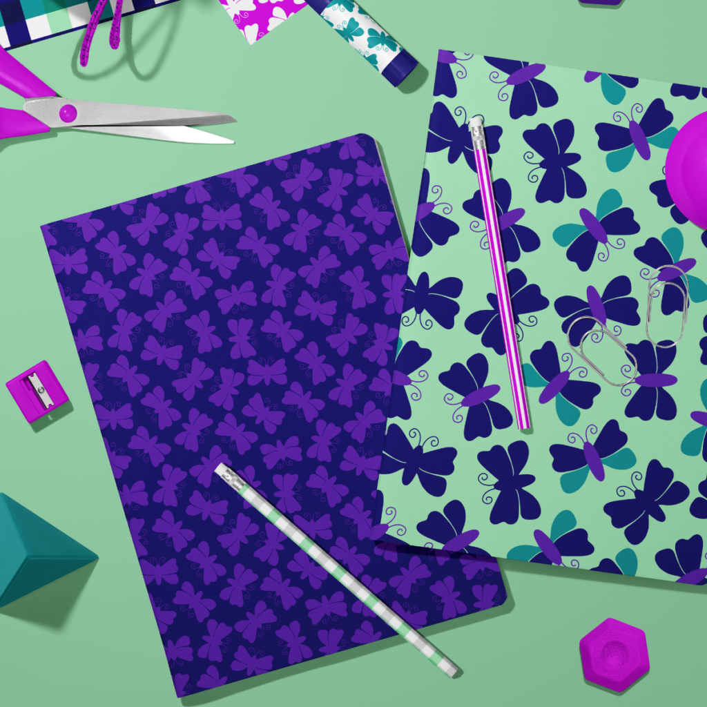 Butterfly pattern notebooks in purple, mint green, and teal styled with matching school supplies.