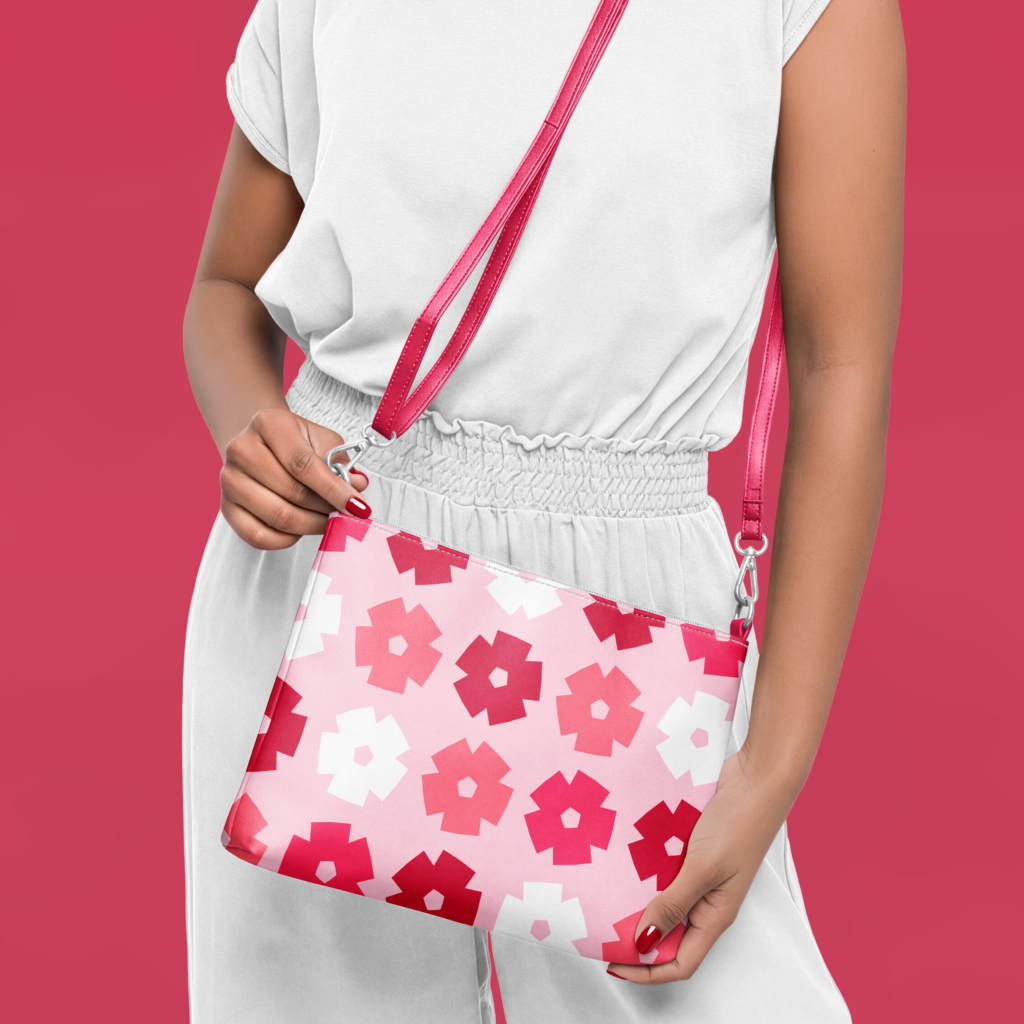 Retro geometric floral crossbody bag in shades of pink, red, and white styled with a white outfit.